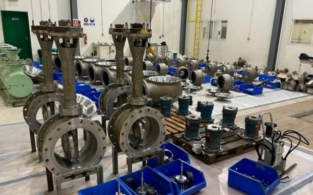 Rows of overhauled cryogenic butterfly valves and actuators on the WCS workshop floor